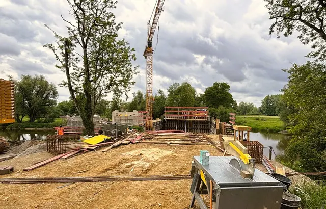 Während rechts Teile der neuen Autobrücke bereits in Schalungen stehen, sieht man links die zwei Brückenpfeiler wo die restaurierte denkmalgeschützte Holzbrücke wieder eingesetzt wird. | Foto: Gruber