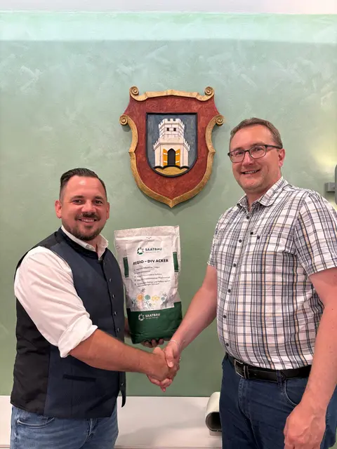Mehr als zwei Tennisfelder voller Blumen für Helpfau-Uttendorf: Der Berater der Gemeinde Oliver Augustin (l.) überreicht Bürgermeister Johannes Manglberger Saatgut für 500 Quadratmeter Blumenwiese. | Foto: Oberösterreichische Versicherung