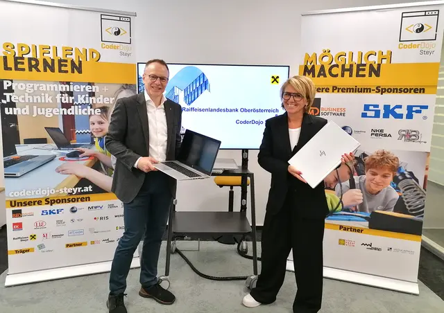Martin Gastgeb übergibt im Namen der Raiffeisenlandesbank OÖ an Daniela Zeiner 25 Laptops für CoderDojo Steyr.  | Foto: Steyr / Stadt.Impuls