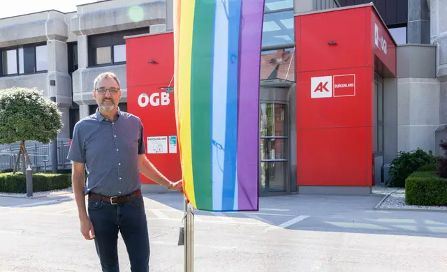 AK Burgenland-Präsident Gerhard Michalitsch mit der Regenbogenfahne vor der Zentrale in Eisenstadt