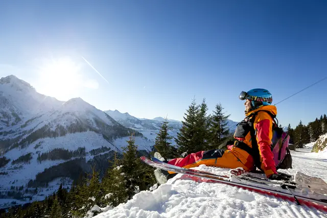 Skifahrerin sitzt im Schnee