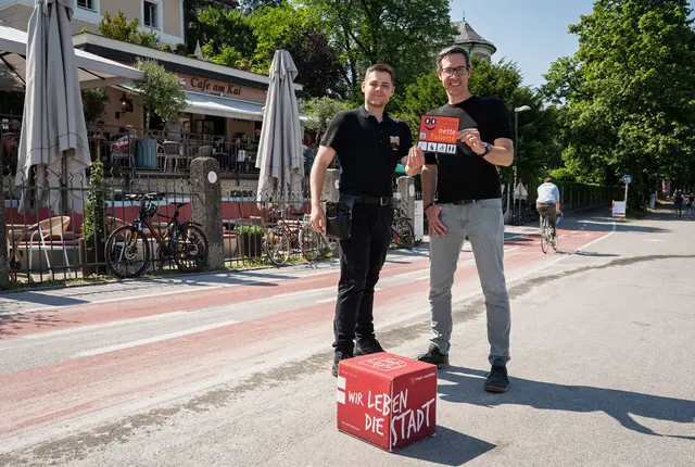 Cafe am Kai macht bei der Aktion „Nette Toilette“ mit
Das Cafe am Kai ist einer von sechs neuen Partnerbetrieben der Aktion „Nette Toilette“. Im Bild v.l.n.r.: Adrian Puraner, Mitarbeiter Cafe am Kai, und Bürgermeister-Stellvertreter Kay-Michael Dankl vor dem Cafe am Kai in Mülln. | Foto: Stadt Salzburg/Alexander Killer