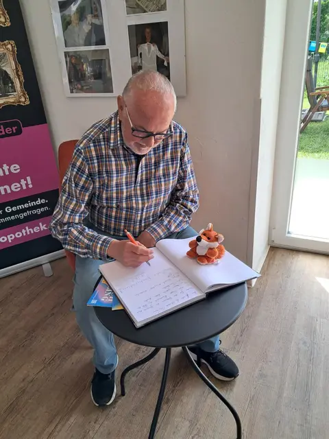 Willi Kornfeld trägt in das Gästebuch ein. | Foto: Binder