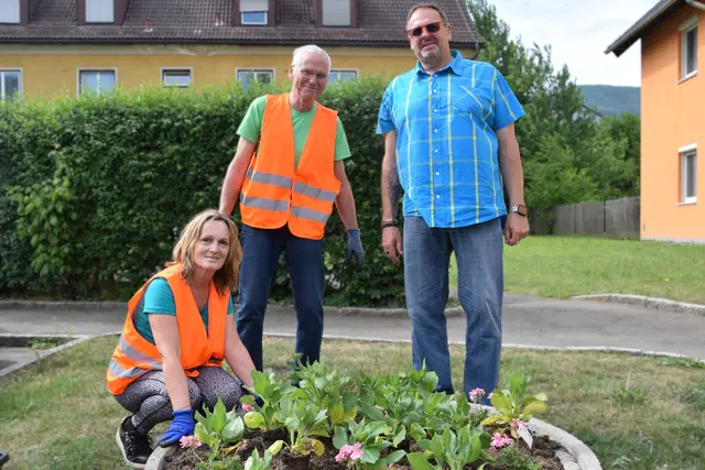 Menschen bei einem Blumenbeet