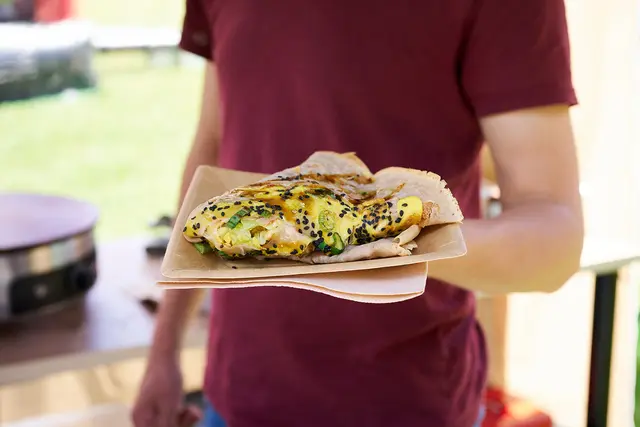 Koch hält einen  Crepe Jianbing in der hand