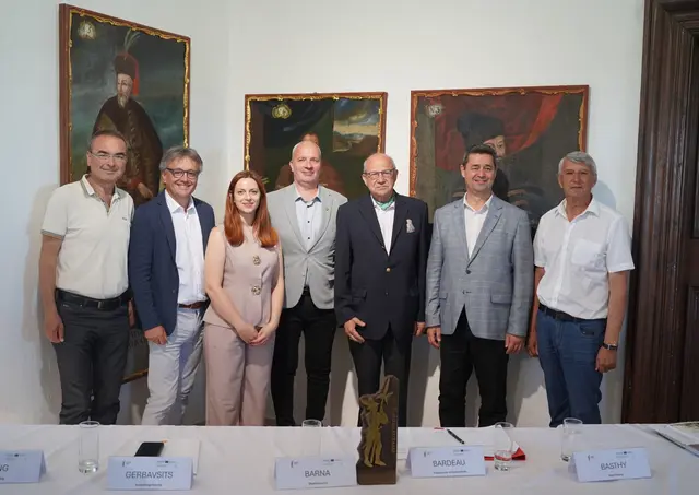 Eine kleine Menschenmenge gruppiert sich für ein Foto.