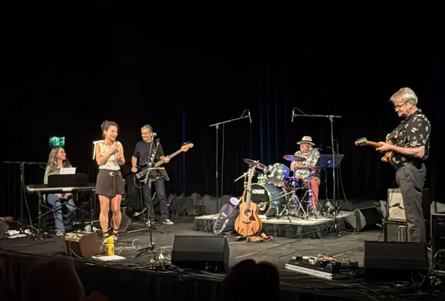 Eine Musikband performt auf einer Bühne.