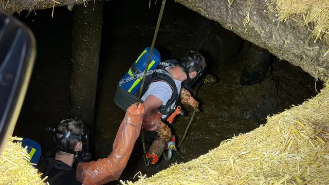 Unter Atemschutz stiegen Feuerwehrleute in die Grube hinab, um das Tier für die Bergung zu sichern. | Foto: ZOOM.TIROL
