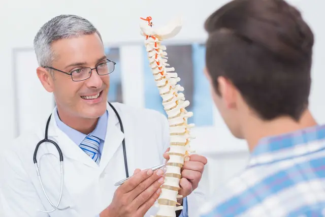 Arzt erklärt Patient die Wirbelsäule