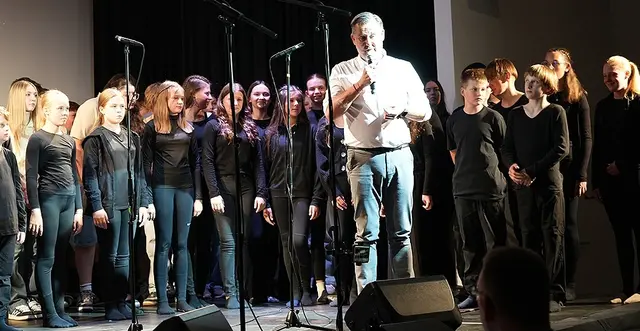 Bürgermeister Andreas Thürschweller auf der Bühne mit den Schülerinnen und Schülern der Musikklassen an der Musikmittelschule Eibiswald. | Foto: Musikmittelschule Eibiswald