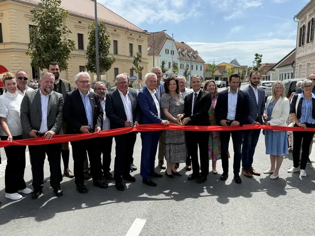 Viele Ehrengäste durchschneiden ein rotes Band  am neuen Hauptplatz in Neudau
