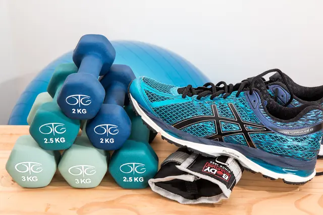Hanteln, Gymnastikball und Sportschuhe für eine Physiotherapie