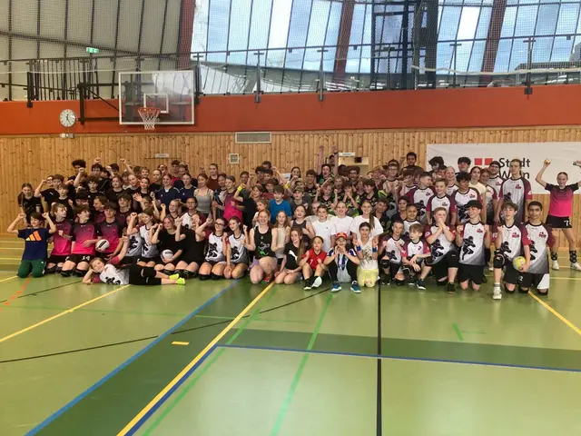 Gruppenfoto aller teilnehmenden Mannschaften beim Finaltag der Dodgeball Youth League Austria in Wien – rund 100 Kinder und Jugendliche in der Sporthalle, viele recken die Faust in die Kamera.