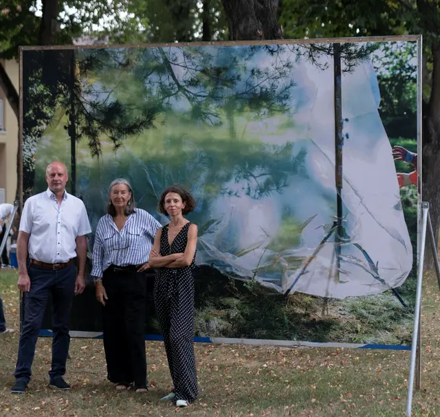 Der Jennersdorfer Bürgermeister Reinhard Deutsch mit Fotografin Elfie Semotan (Mitte) und Kuratorin Katrin Bucher-Trantow vor einer Plakatwand in Mogersdorf. | Foto: David Kranzelbinder