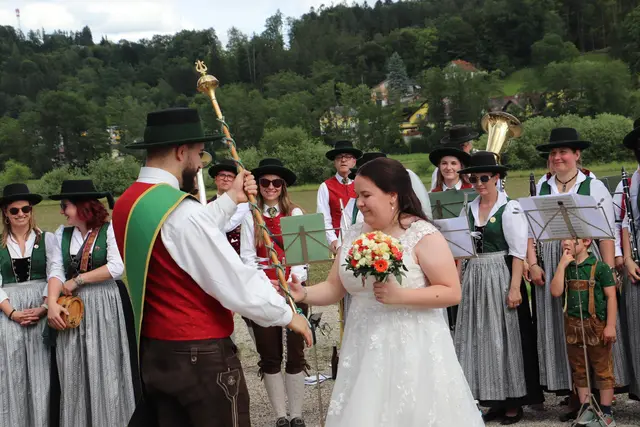 Zur Überraschung der frischgebackenen Frau Kemmer, drückte Maximilian Uggowitzer Teresa Kemmer den Taktstock in die Hand. "Ich soll dirigieren?", war die junge Ehefrau baff. Und sie machte ihre Sache gut,  gab den Takt an - und Gatte Christian spielte in der gemischten Musikkapelle das Flügelhorn, schön nach den Vorgaben seiner Frau.  | Foto: Edith Ertl