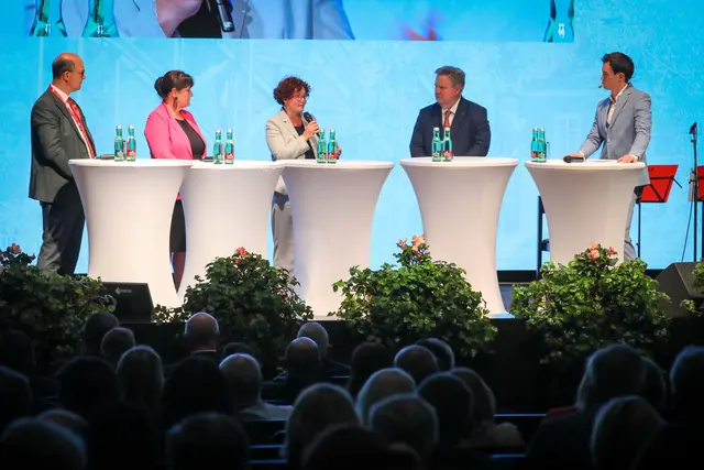 Menschen stehen am Podium