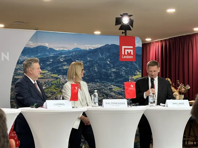 Menschen hinter Stehtischen, Mann spricht mit Mikrofon