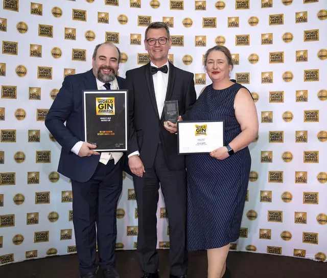 David T. Smith (links, World Gin Awards Chair of Judges), Anita Ujszaszi (rechts, Awards director ) Simon Alber (Mitte), Master Distiller von Simon Alber Spirits GmbH, mit der Trophy für den „World's Best Matured Gin 2026“. Aufgenommen am 2. Juni 2026 bei der Preisverleihung der World Drinks Awards im Waldorf Hilton London. | Foto: World Drinks Awards