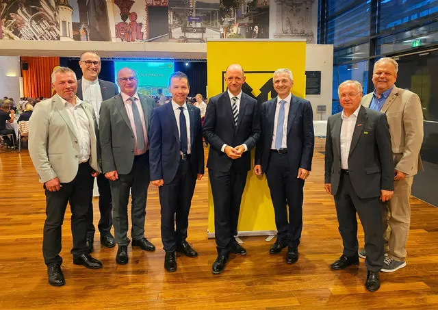 Acht Männer haben sich für ein Gruppenfoto aufgestellt.