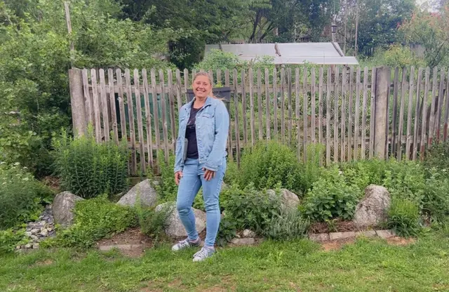 Frau steht vor Kräutergarten