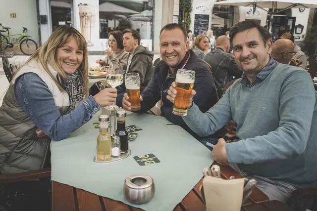 Menschen stoßen mit Bier an