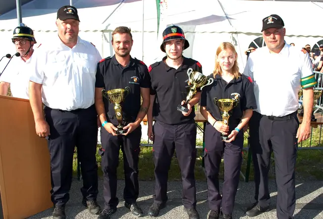 Feuerwehrleute mit Pokalen in der hand