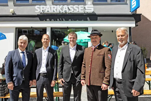 Regional verwurzelt, gemeinsam in die Zukunft: Das Jubiläumsfest der Sparkasse in Jenbach brachte Menschen und Traditionen in der Begegnungszone zusammen. (v. l. n. r.: Bgm. Dietmar Wallner, VDir. Thomas Schiendl, FL Michael Deutsch, Kapellmeister Markus Astner sowie der ehem. Filialleiter DirR. Egon Neuner)