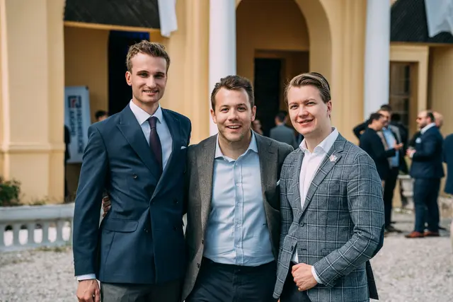 3 Männer stehen vor einem Gebäude