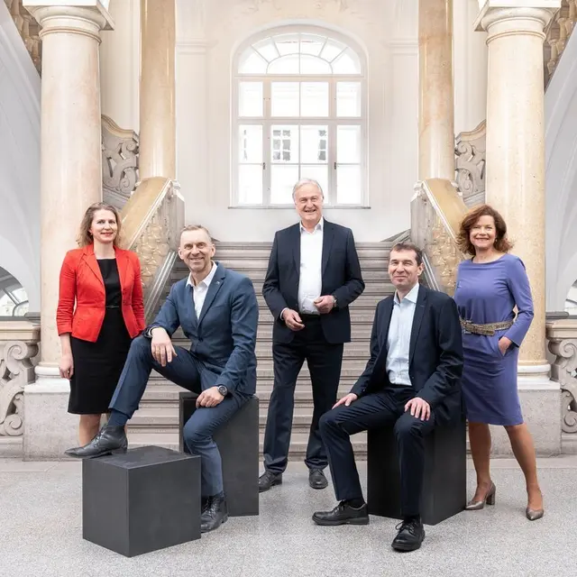 5 Personen stehen in einem Stiegenhaus