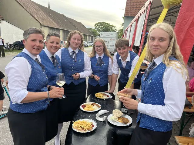 Gruppe in Tracht am Stehtisch mit Essen