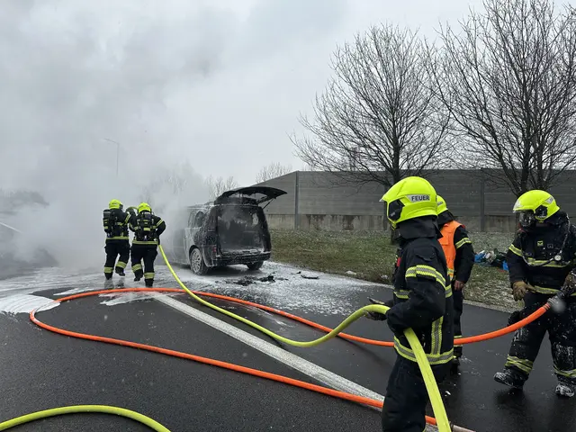 Feuerwehrmenschen beim Löscheinsatz mit Schaum