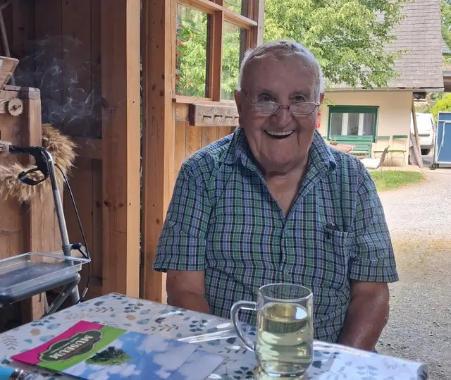 Mit einem Lächeln im Gesicht und einem kühlen Getränk genießt Bewohner Franz Mauthner die unbeschwerte Urlaubsstimmung.