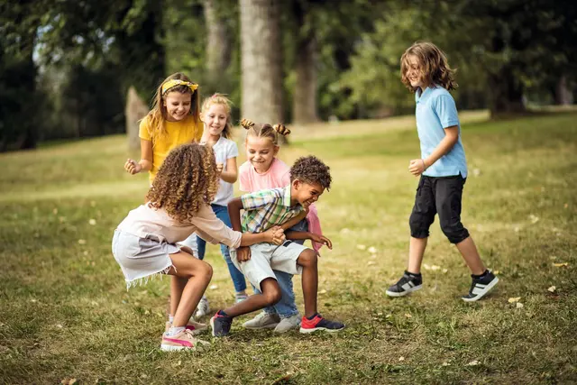 Spielende Kinder auf einer Wiese.