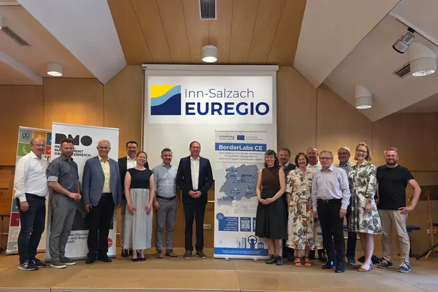Die Vorstandsmitglieder der Inn-Salzach Euregio, Mitarbeiter der RMOÖ GmbH und des Landes OÖ und der Gastgeber, Bürgermeister in Pram, Georg Schamberger vor dem neuen Inn-Salzach Euregio Logo.  | Foto: RMOÖ