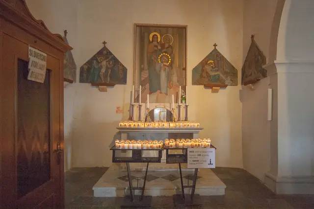 Die Opferkerzen sind beim Eingang der Kirche zu erwerben. An den Wänden sind Darstellungen von Kreuzwegstationen. Siehe dazu auch Infotafel Teil 1 und 2. | Foto: © by Ing. Günter Kramarcsik