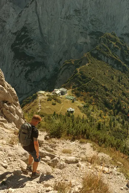Wanderer steigt am Wilden Kaiser ab mit Blick im Hintergrund auf die Stripsenjochhütte