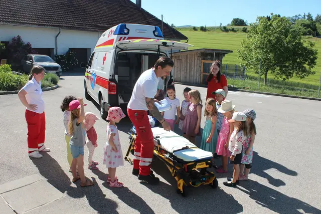 ROKO-Mitarbeiter Andreas Kerle-Kelz und Jugend-Koordinatorin Nadine Haupert (beide in RK-Uniform) erklären ihnen kindgerecht was im Notfall zu tun ist und welche Geräte es für so manchen Notfall brauchen könnte. | Foto: ÖRK, Tanja Auer