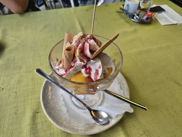 Holiday-Eisbecher mit Mangoeis, Mandeln und Erdbeersauce – fruchtig-süßer Abschluss. | Foto: Genussspecht