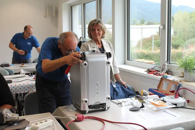 Ein Mann und eine Frau reparieren ein elektronisches Gerät
