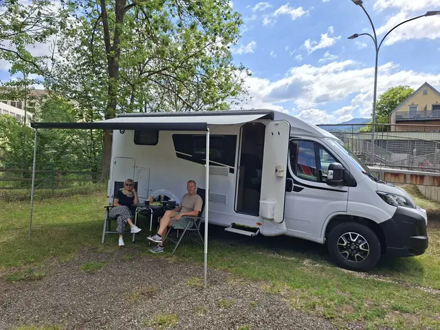 Ein Paar sitzt vor einem Wohnmobil