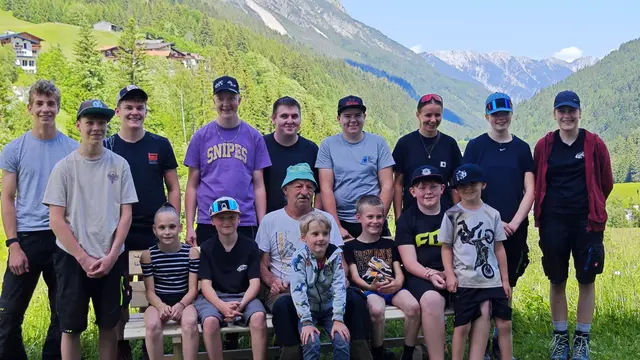 Die Kinder aus Hinterhornbach bedankten sich bei ihrem langjährigen Schulbusfahrer mit einer selbst gefertigten Holzbank. Auf dem Erinnerungsfoto sind 15 Kinder aus Hinterhornbach zu sehen; lediglich Sepps Tochter Selina fehlt darauf. | Foto: Lechleitner