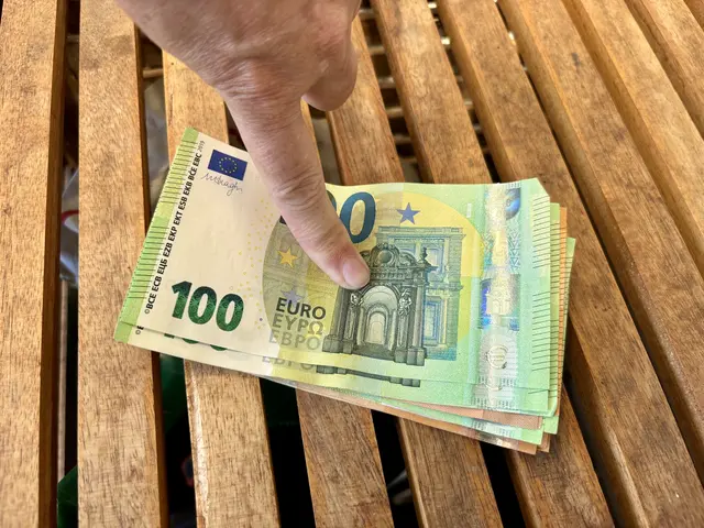 Geldbündel mit Finger drauf