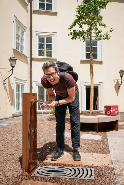 Bürgermeister-Stellvertreter Kay-Michael Dankl beim neuen Brunnen auf der sanierten Innenhofterrasse im Haus der Natur. | Foto: Stadt Salzburg/Alexander Killer