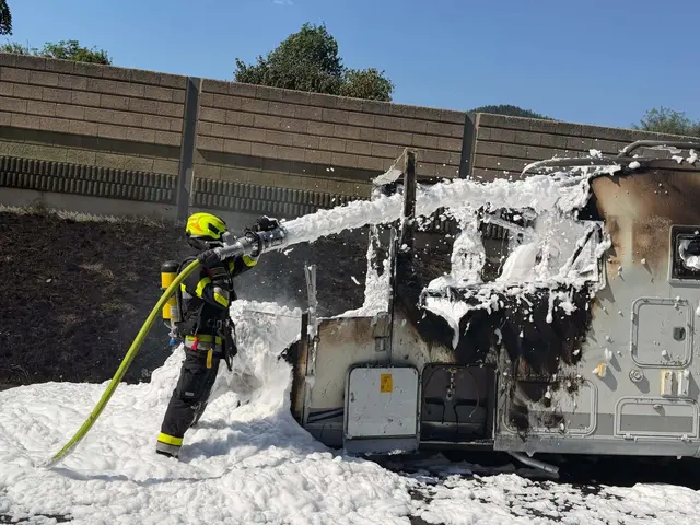 Ein Feuerwehrmann löscht ein Wohnmobil mit Löschschaum ab