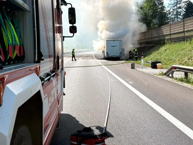 Feuerwehrmänner löschen ein brennendes Wohnmobil