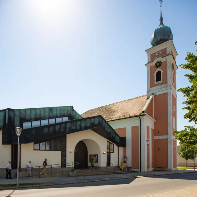 Der kleine alte Kirchenteil der Illmitzer Pfarrkirche im Hintergrund mit dem im Vordergrund neu hinzugebauten geräumigen Kirchenraum. 