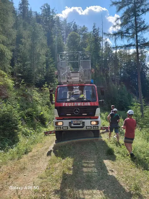 Feuerwehrauto und 2 Männer stehen daneben