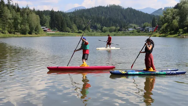 3 Skijakfahrer am Wasser mit Paddel in der Hand