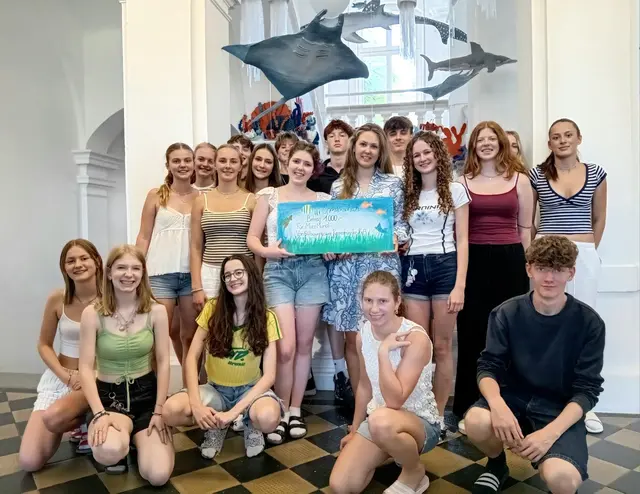 Die 6B mit dem Spendenscheck vor der Unterwasserwelt im Stiegenhaus. | Foto: Stiftsgymnasium Kremsmünster