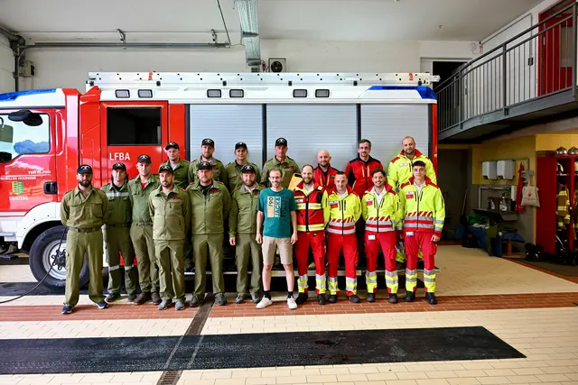 Das schönste Bild nach dramatischen Ereignissen: Der Feuerwehrmann (grünes T-Shirt) inmitten seiner beteiligten Kameraden und der Rettungsteams. | Foto: Hassl